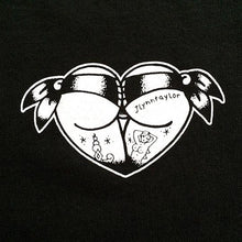 Load image into Gallery viewer, Tattoo style butt heart logo on black t-shirt close up.