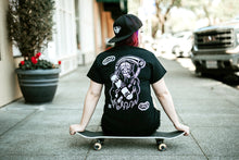 Load image into Gallery viewer, Female model sitting on skateboarding wearing tattoo style skateboard reaper t-shirt.