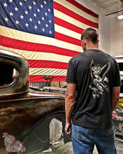 Load image into Gallery viewer, Male with hot rod wearing a tattoo style eagle and pinup shirt in front of American flag.
